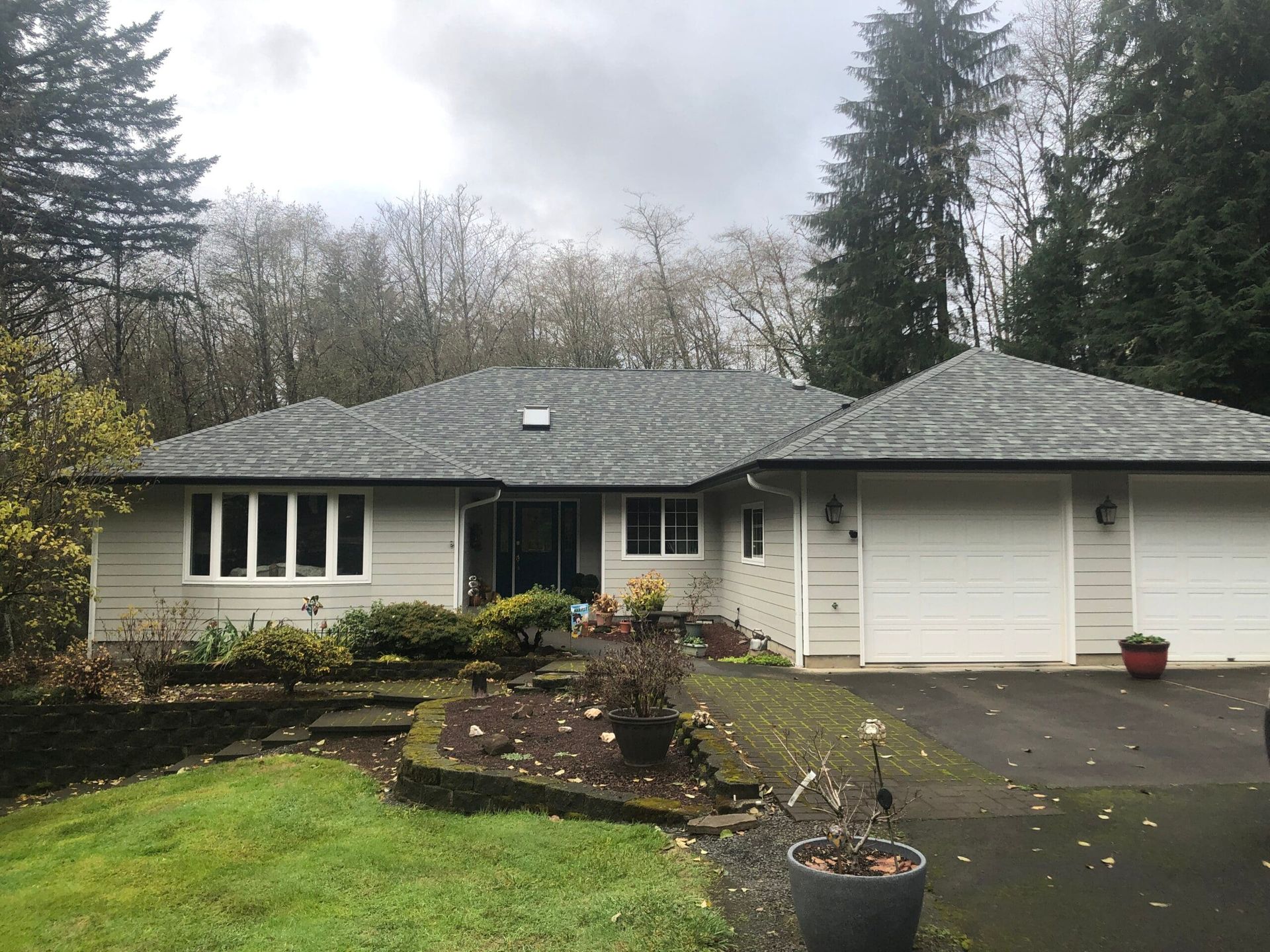 a house with a gray roof and white garage doors