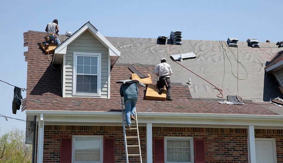 two men are working on the roof of a house