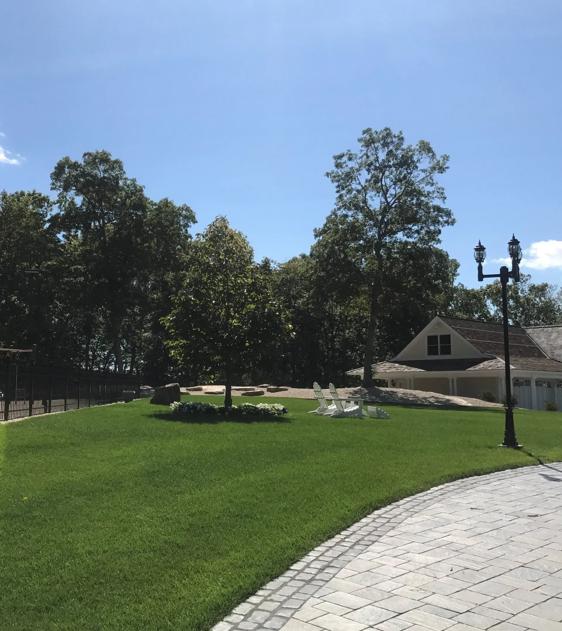 A driveway leading to a house with a lot of grass and trees