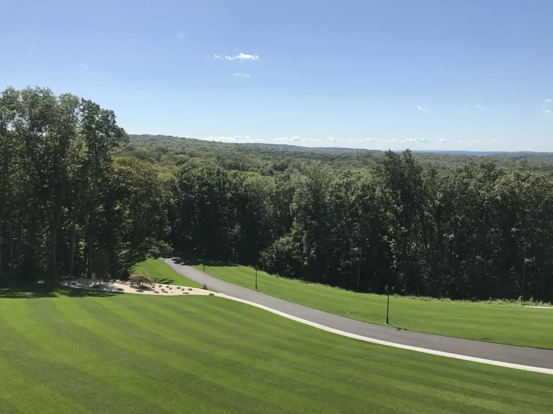 An aerial view of a golf course with trees in the background