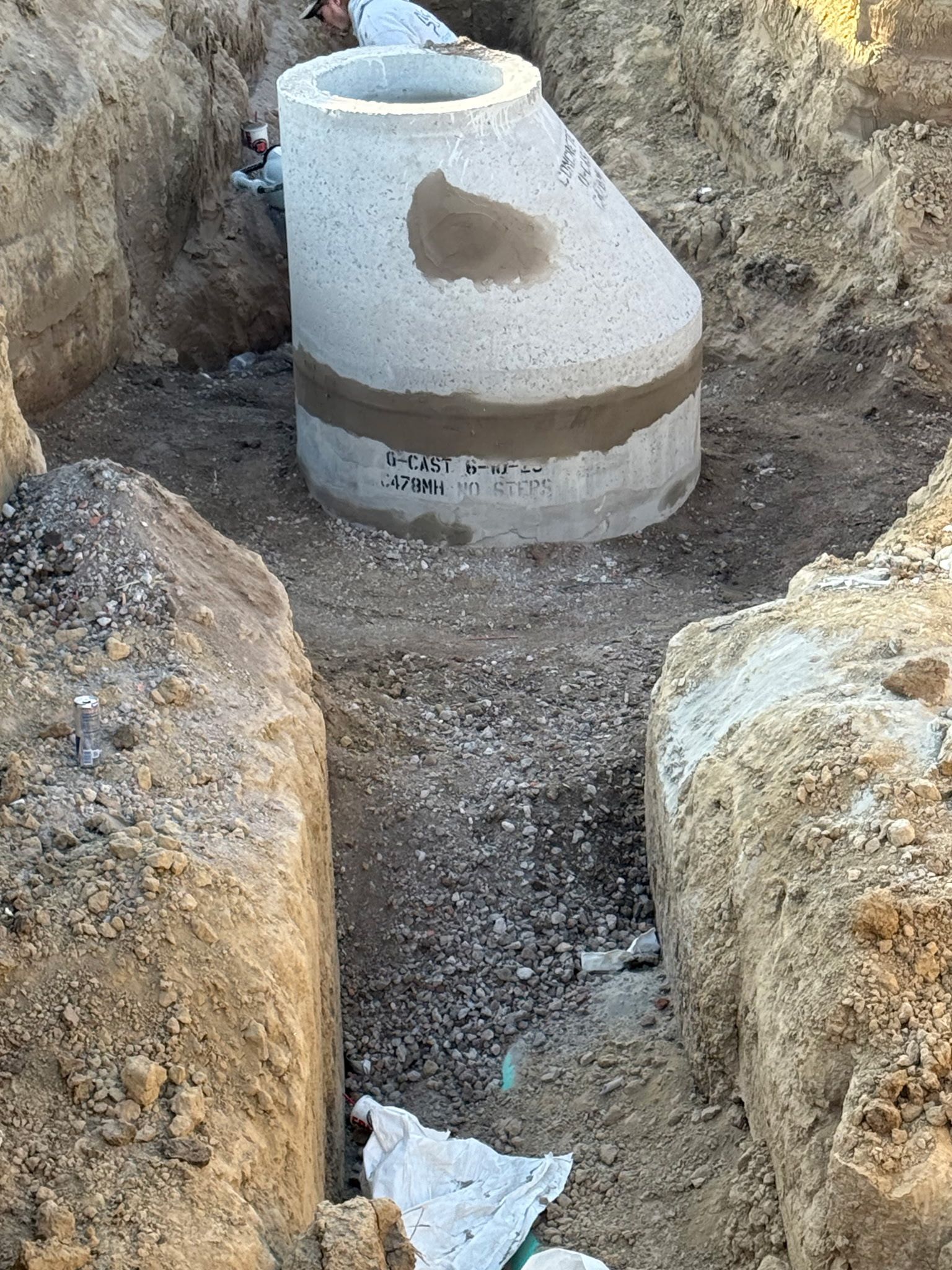 Concrete drainage structure in an excavated trench, possibly under construction.
