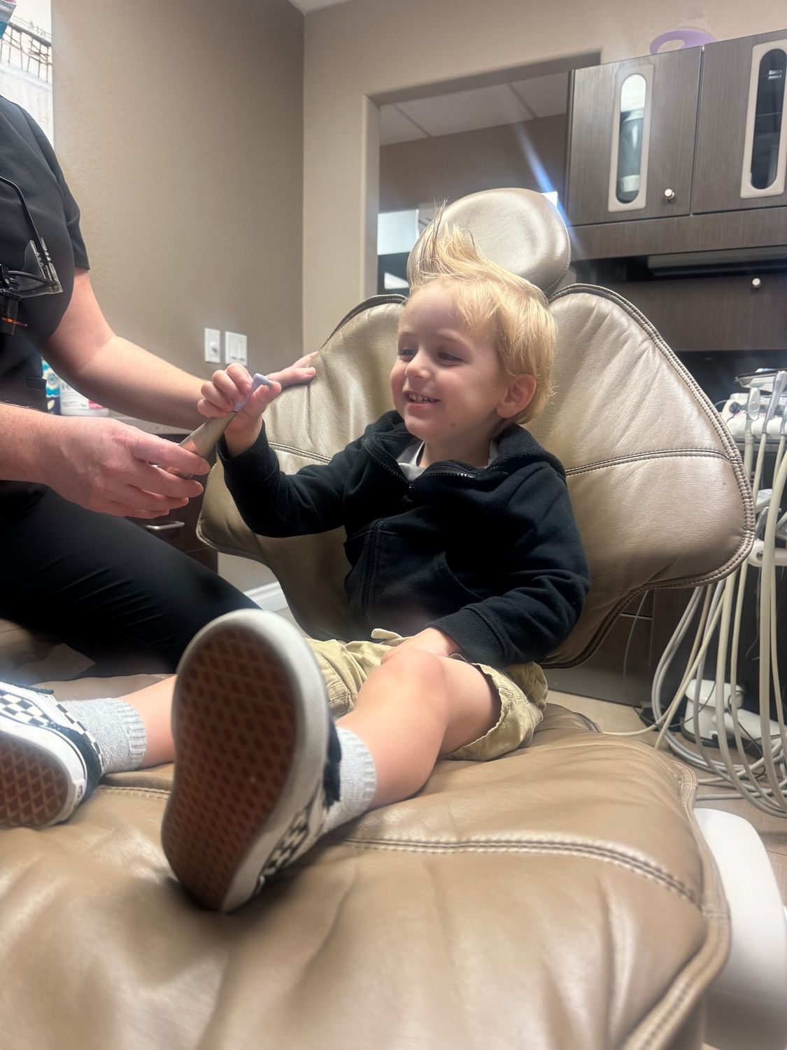 A blond child sat on a dental chair
