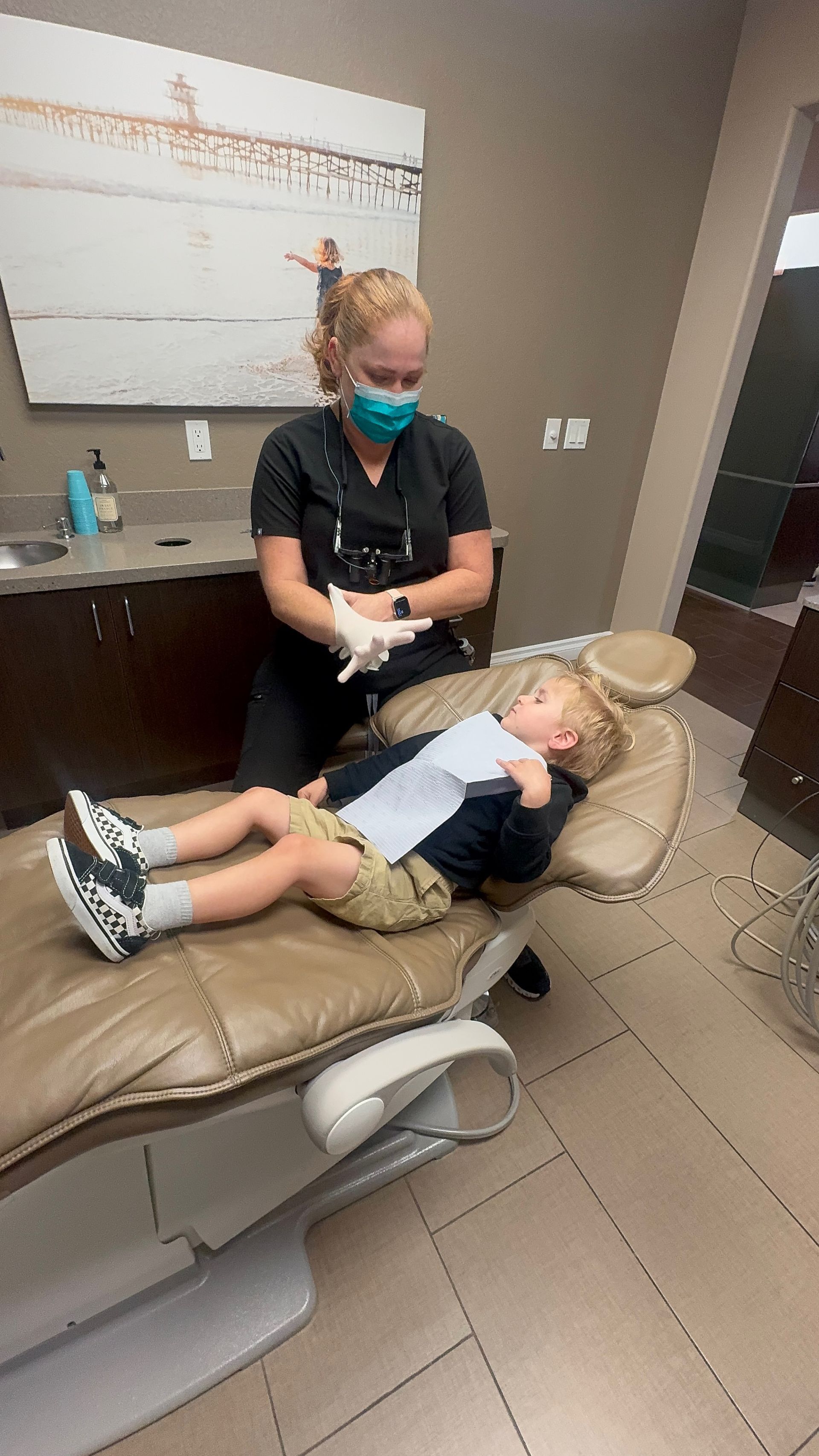 A child lying on a dental chair