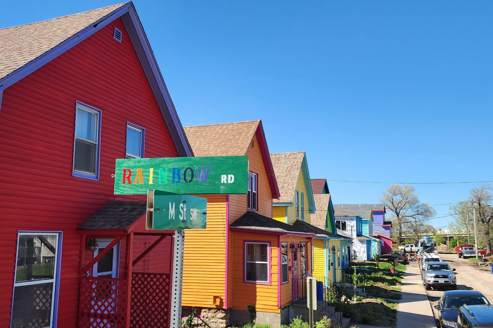 Colorful wooden storefronts and houses lining a sunny street under a clear blue sky