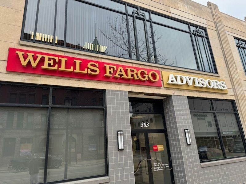 Wells Fargo Advisors office with red and gold sign on a beige building.