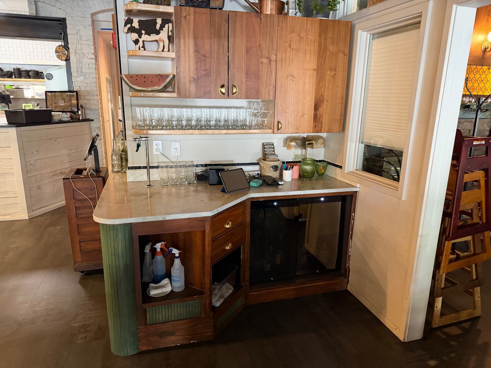 Small kitchen with wood cabinets, counter, sink, and an open door to a sunroom