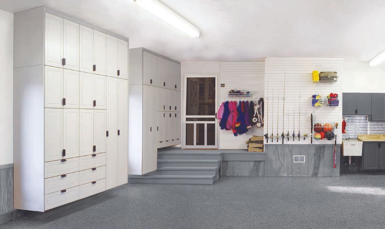 Bright locker room with white cabinets, gray steps, hanging clothes, and storage shelves