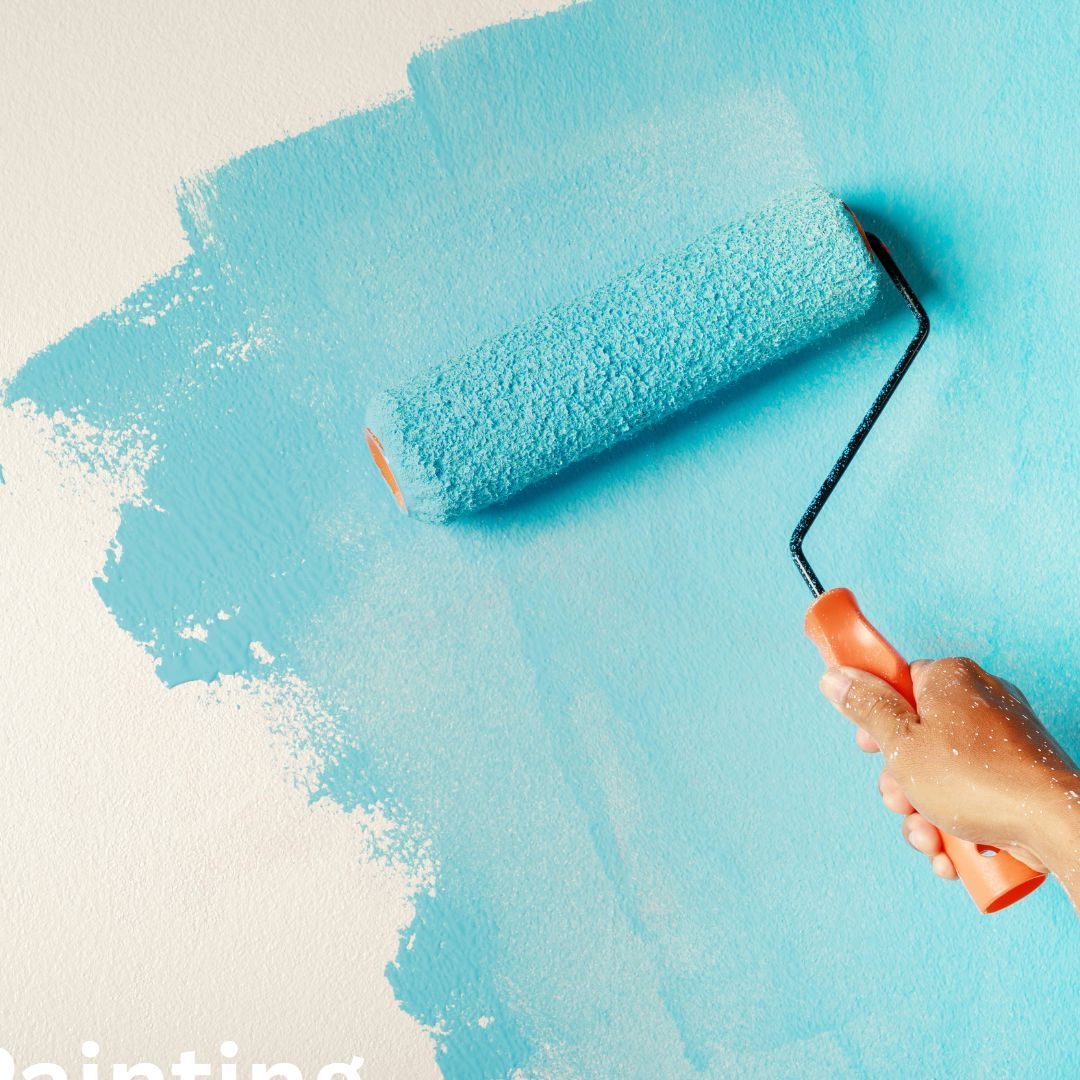 Hand painting a wall with a light blue paint roller on white background