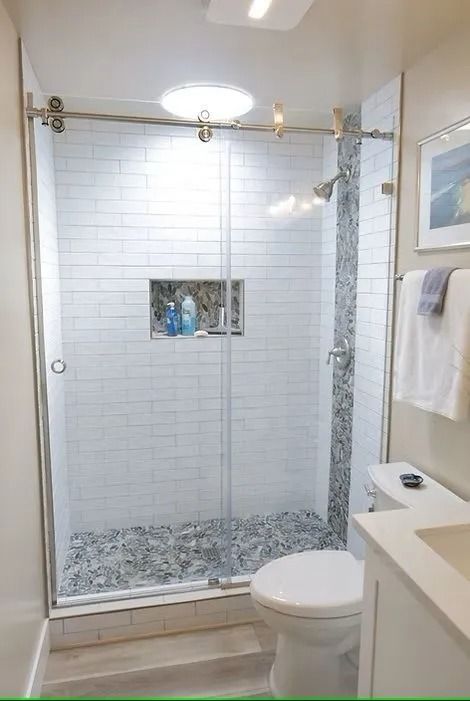 Modern bathroom with a glass shower, white and gray tile, and a toilet.