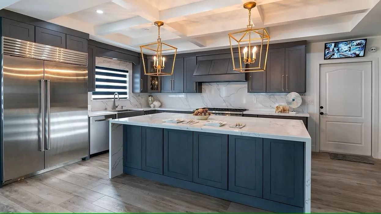 Modern kitchen with gray cabinets, white countertops, and gold light fixtures.