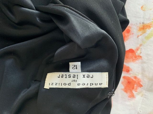 Black fabric with a white clothing tag reading “decorate,” upside down.