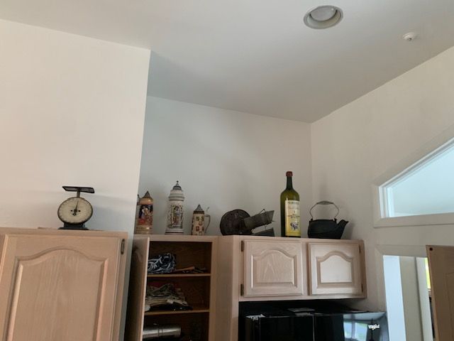 Kitchen corner with cabinets, decorative items, and a slanted ceiling window