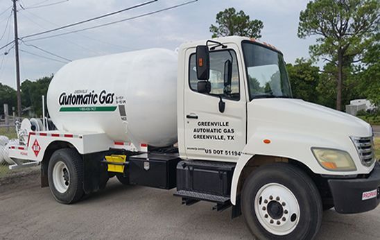 White propane gas truck from Greenville, TX, parked on the street.