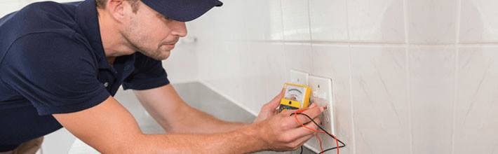 Electrician working at plug socket in a kitchen