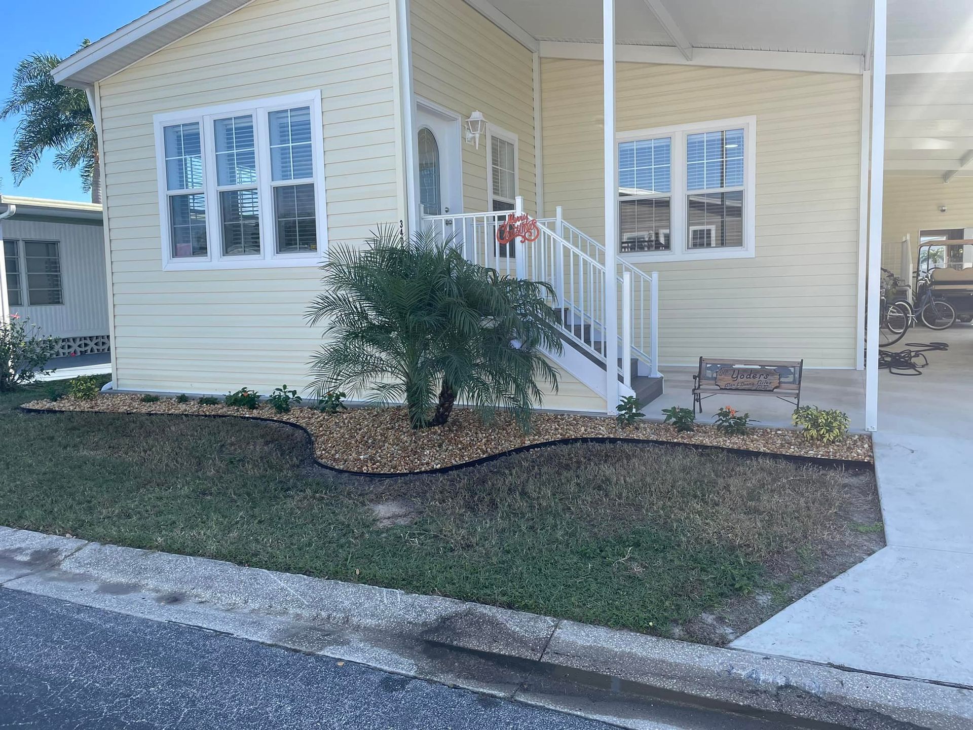 Yellow house with white trim, small garden, and covered patio.