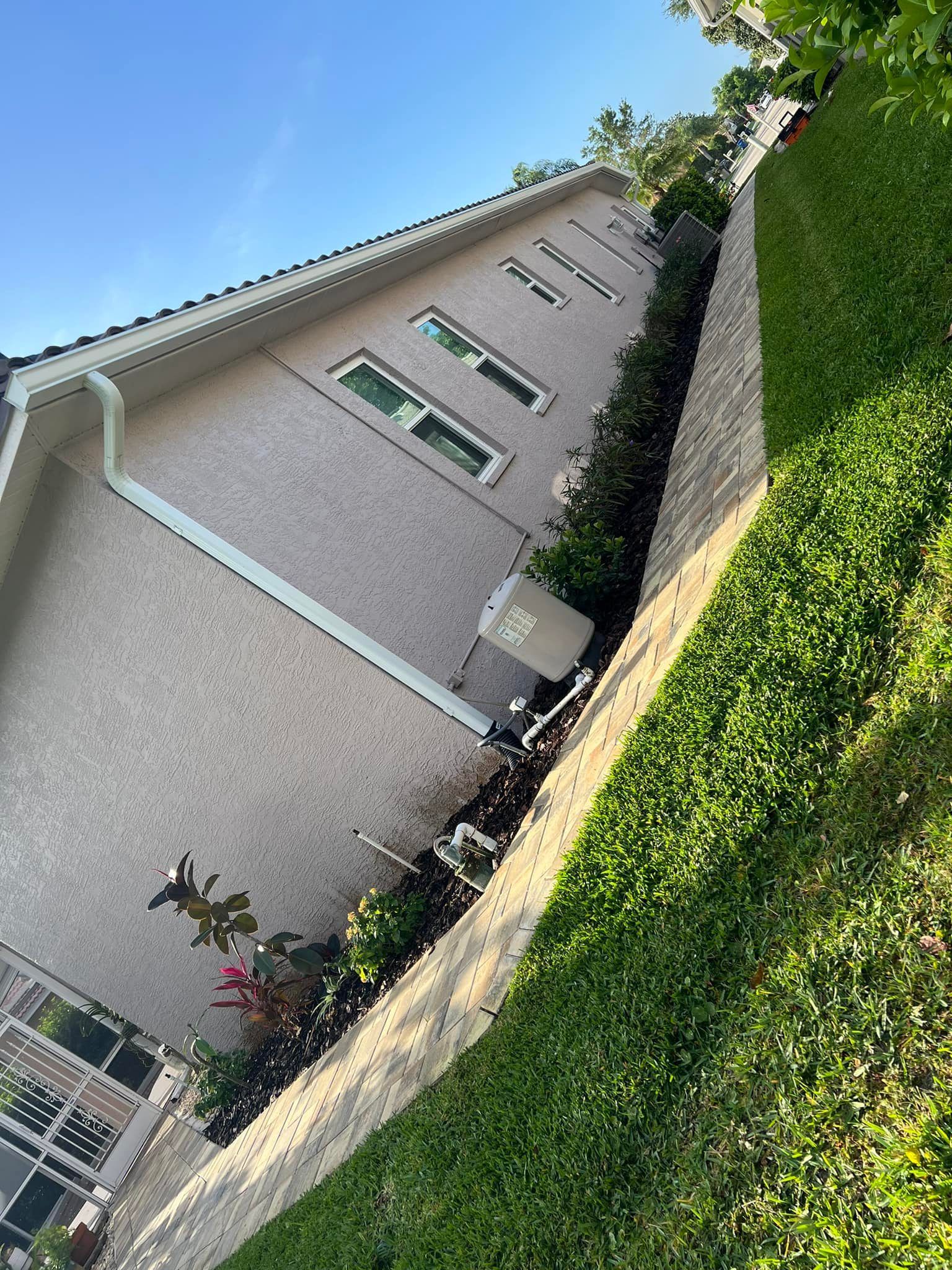 Beige stucco house with a green lawn.