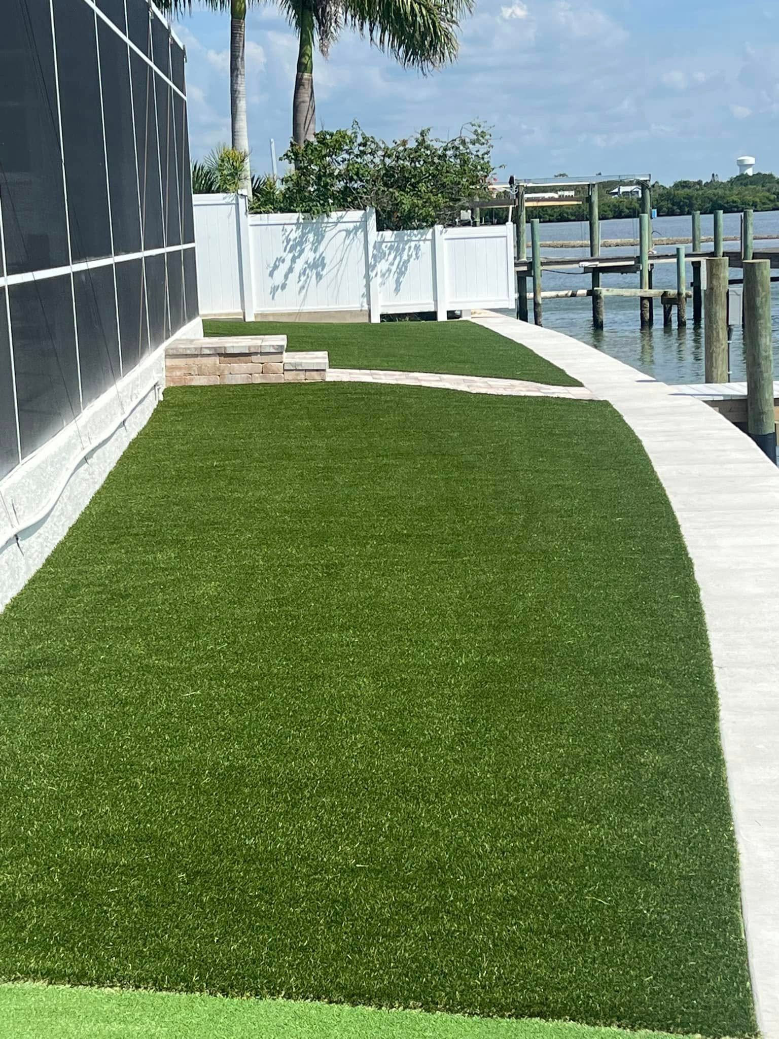 Green artificial turf next to a building and a dock on a sunny day.