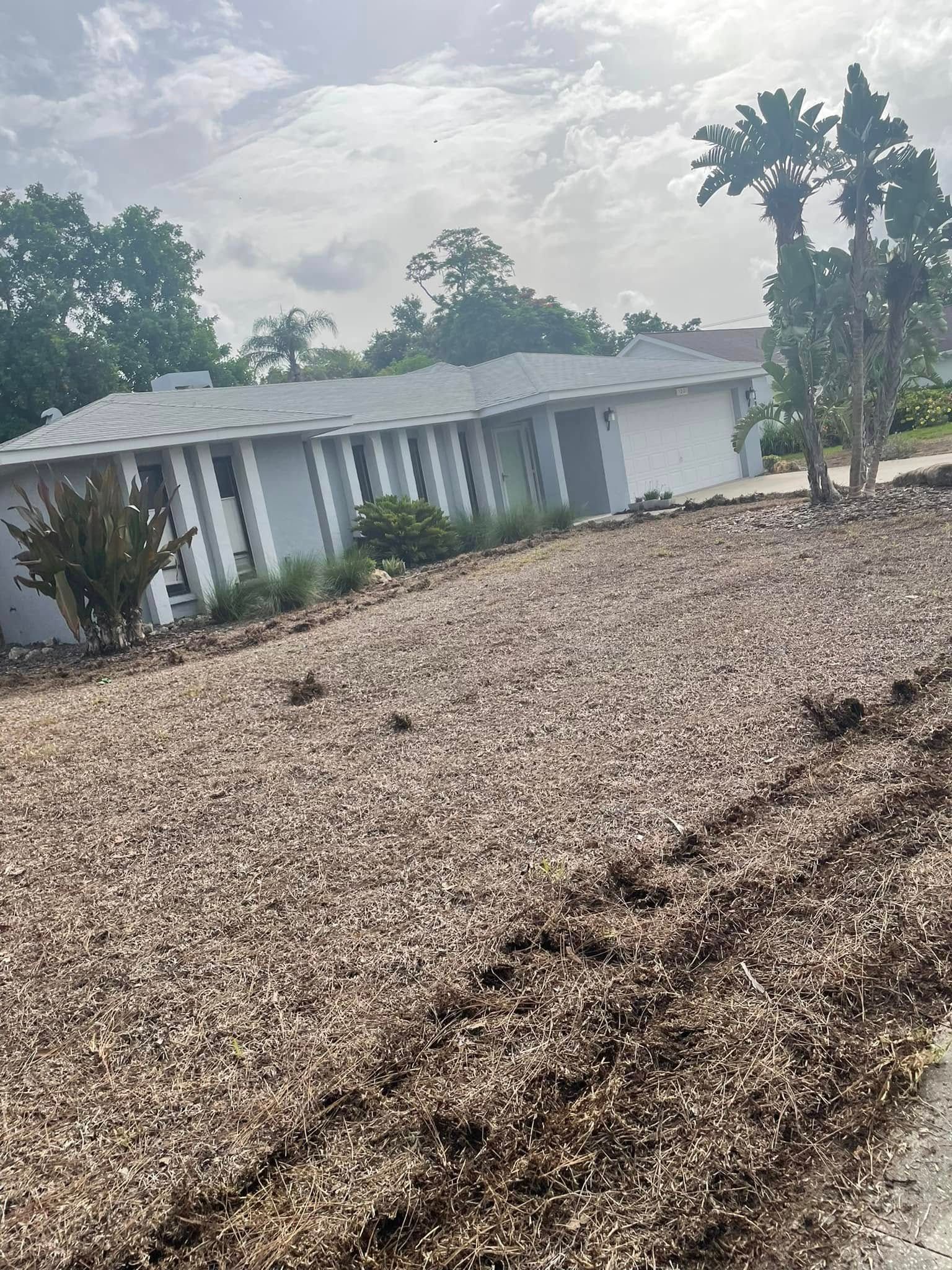 House with brown landscaping stones, cloudy sky.