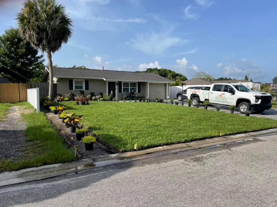 A suburban home with a well-manicured lawn and a landscaping truck parked in front.