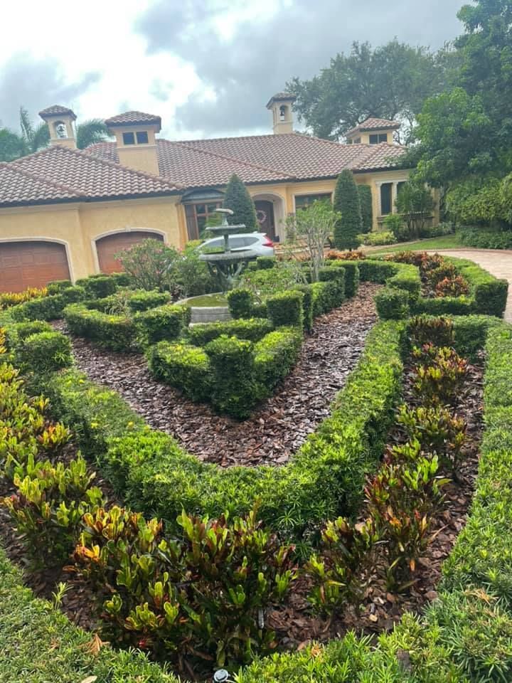 Elegant home with manicured hedges and a central fountain in front.