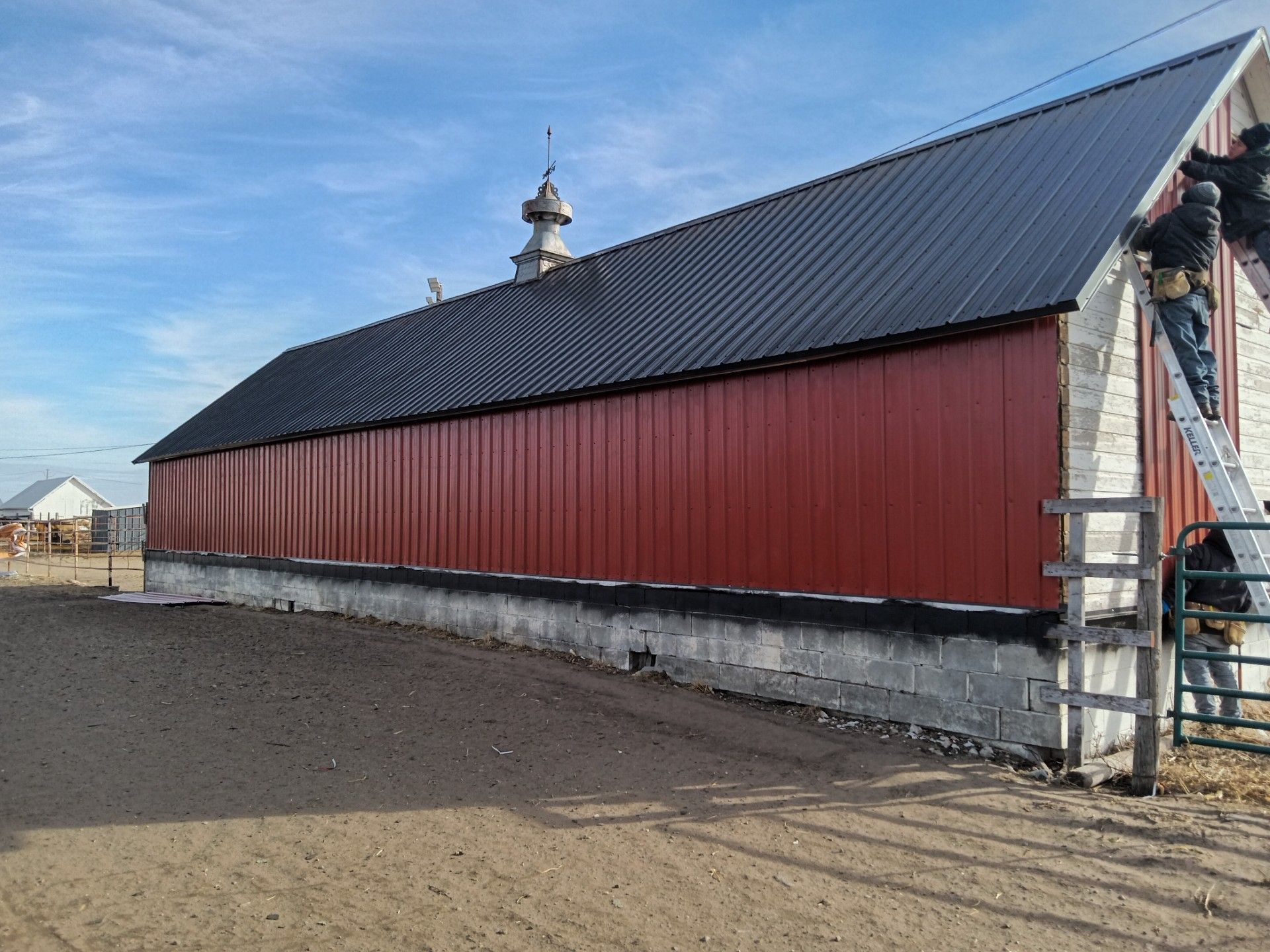 A white car is parked on the side of the road in front of a house.