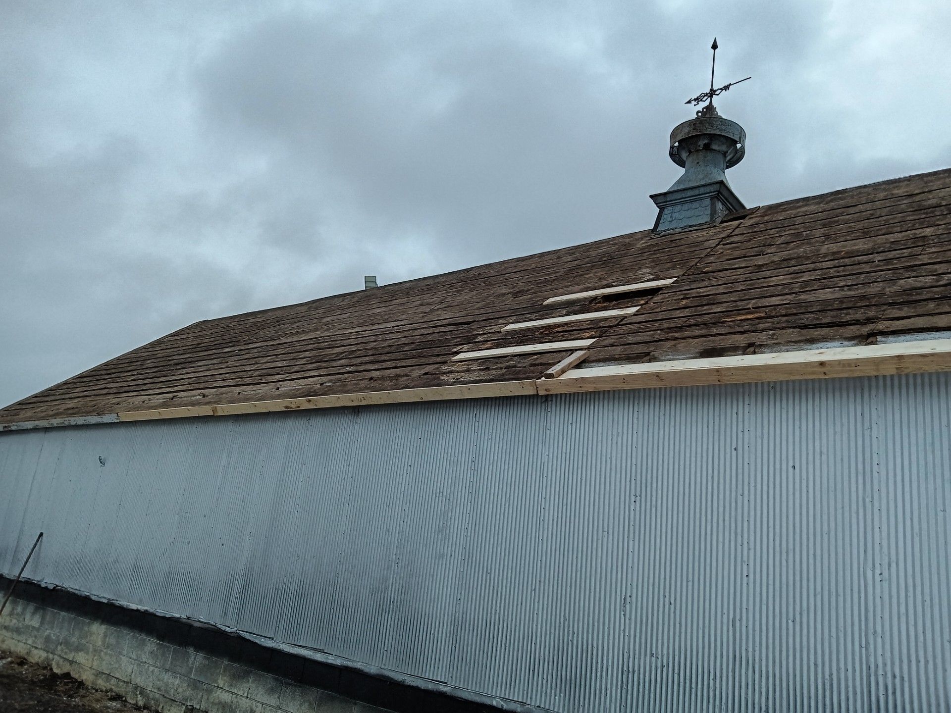 A roof with a weather vane on top of it
