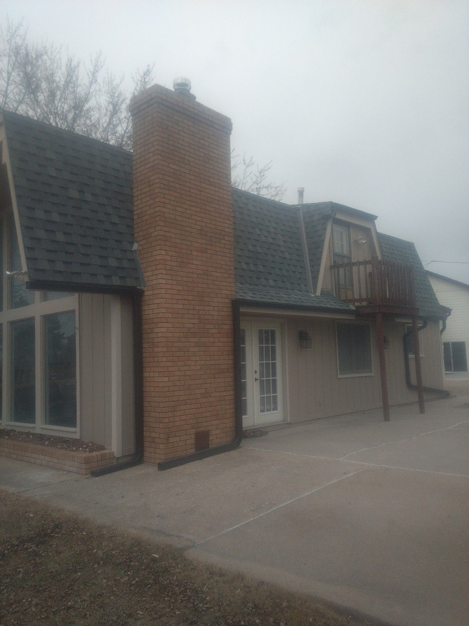 A house with a brick chimney on the side of it.
