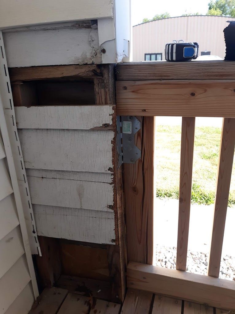 A wooden railing is attached to the side of a house