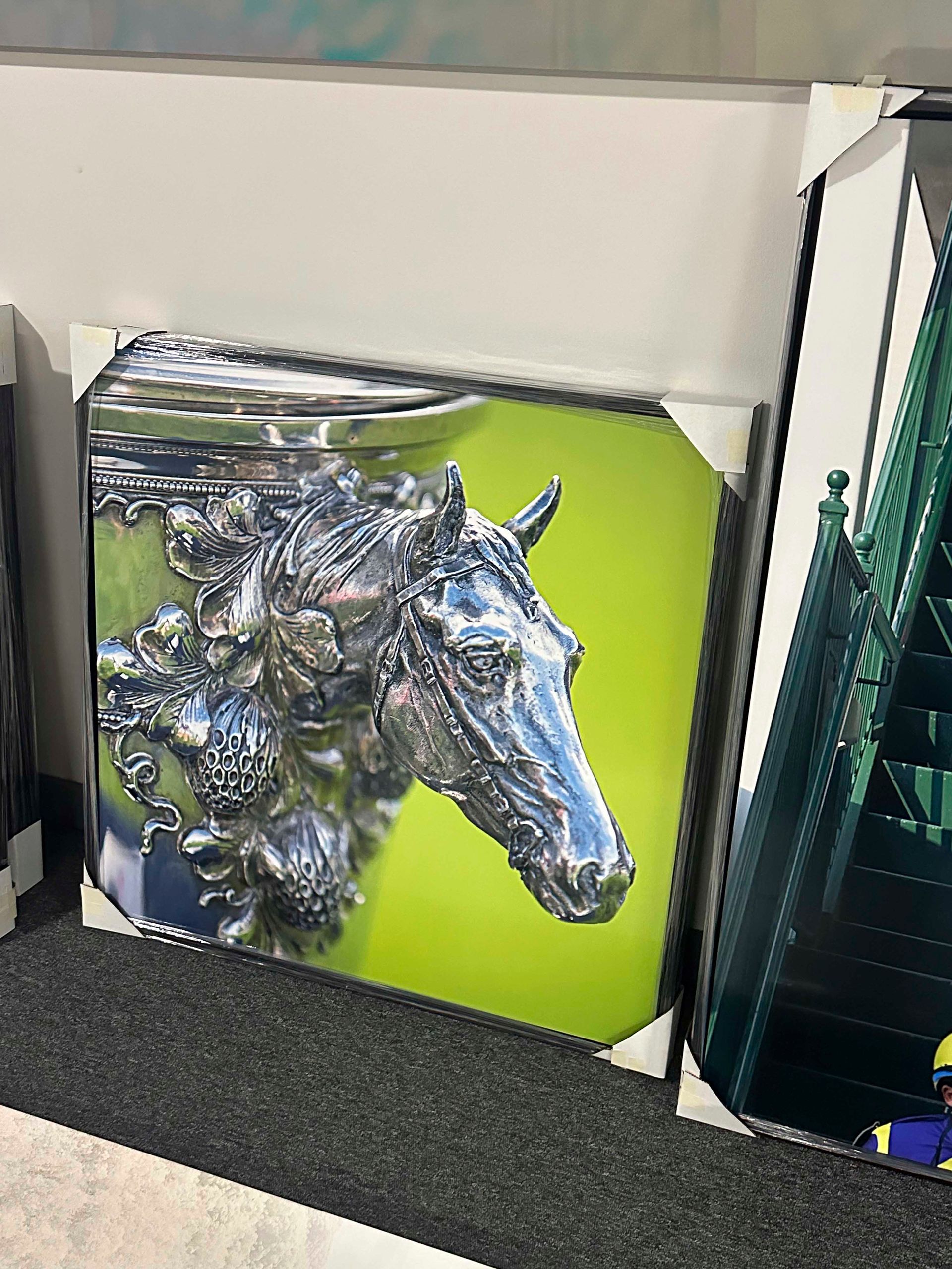 Silver horse head art on a lime green background.