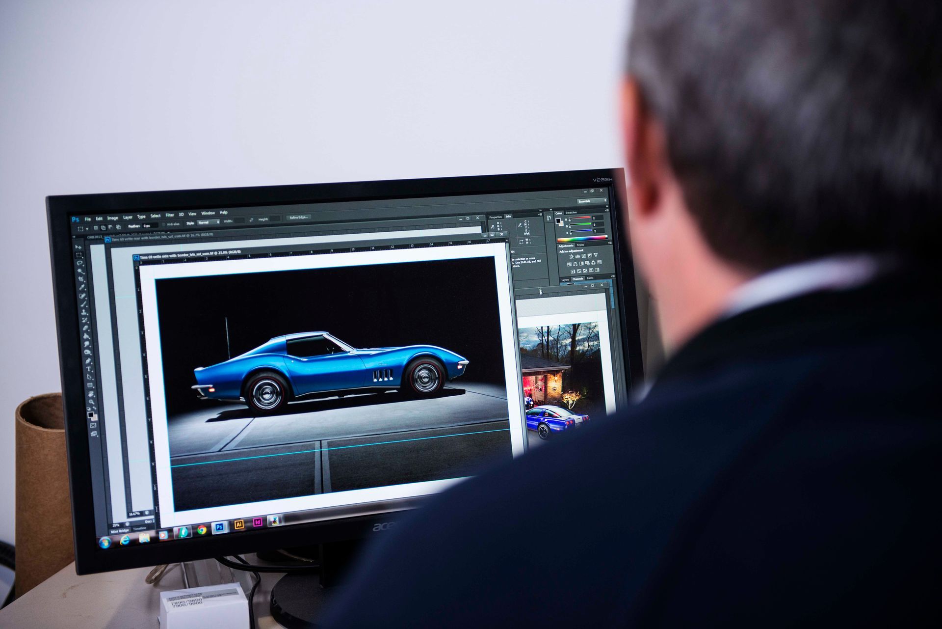Person editing a photo of a blue sports car on a computer screen.