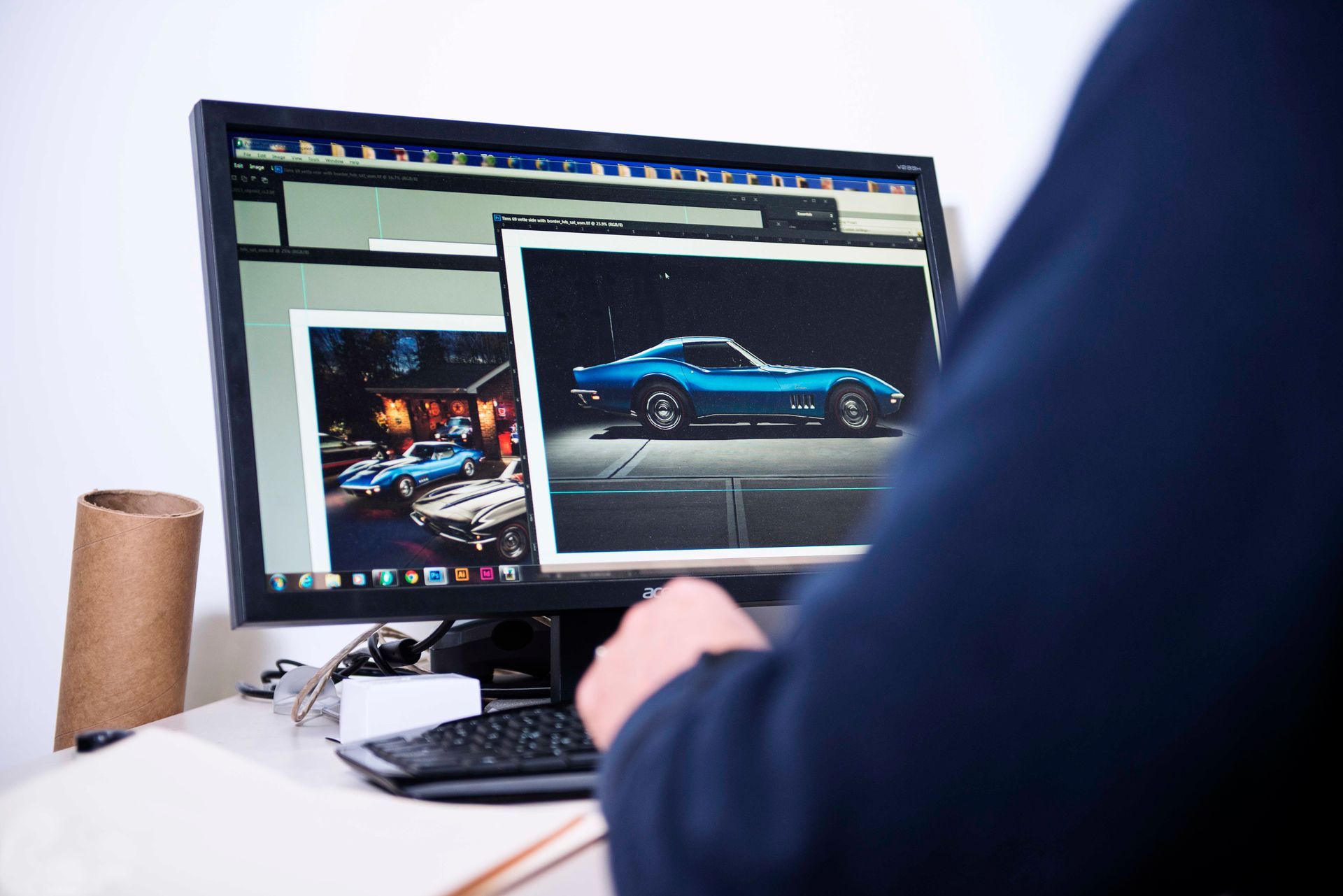 Person editing photos of a blue sports car on a computer screen.