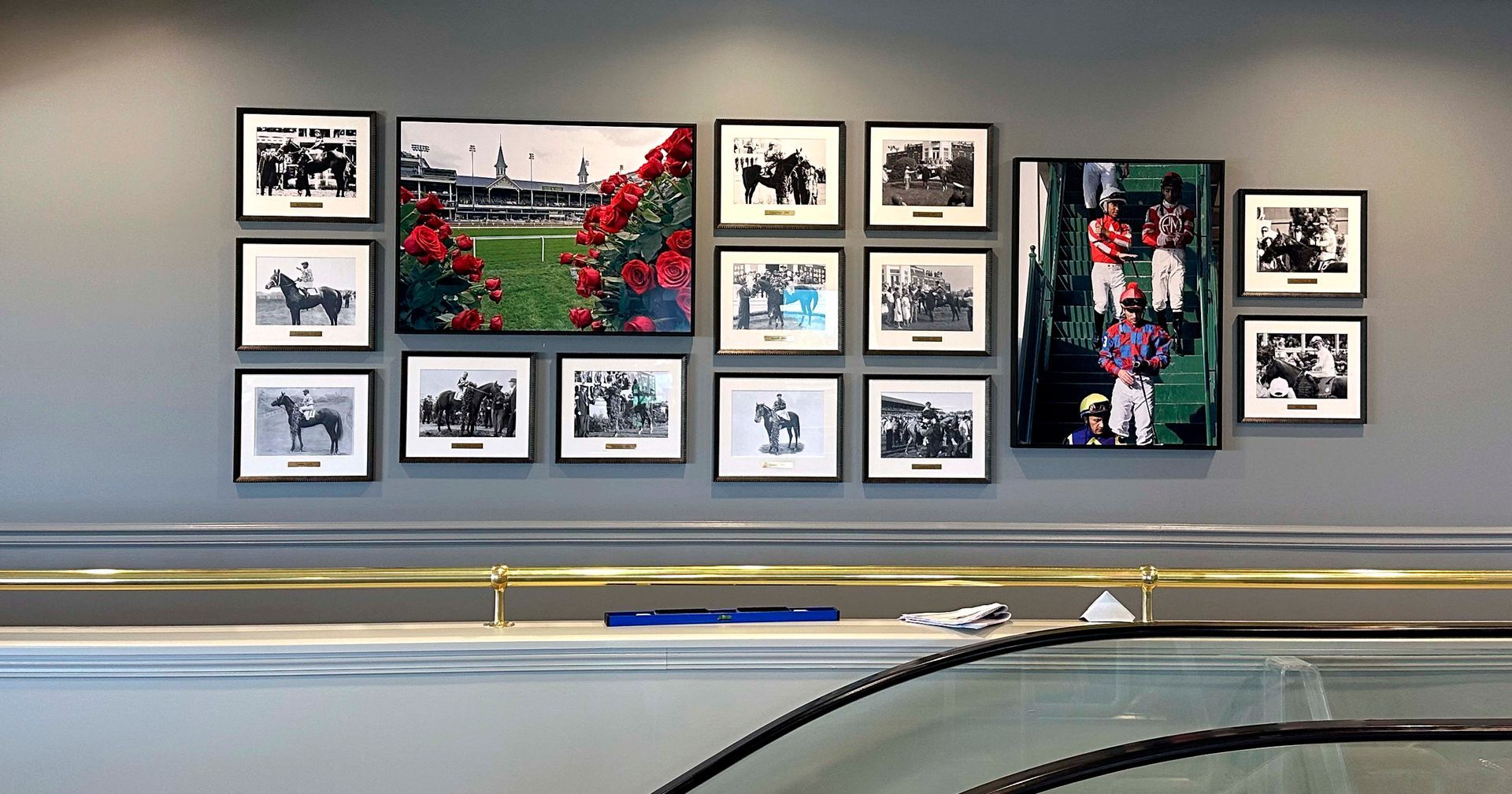 Wall display of framed horse racing photos and a large, colorful racing scene.