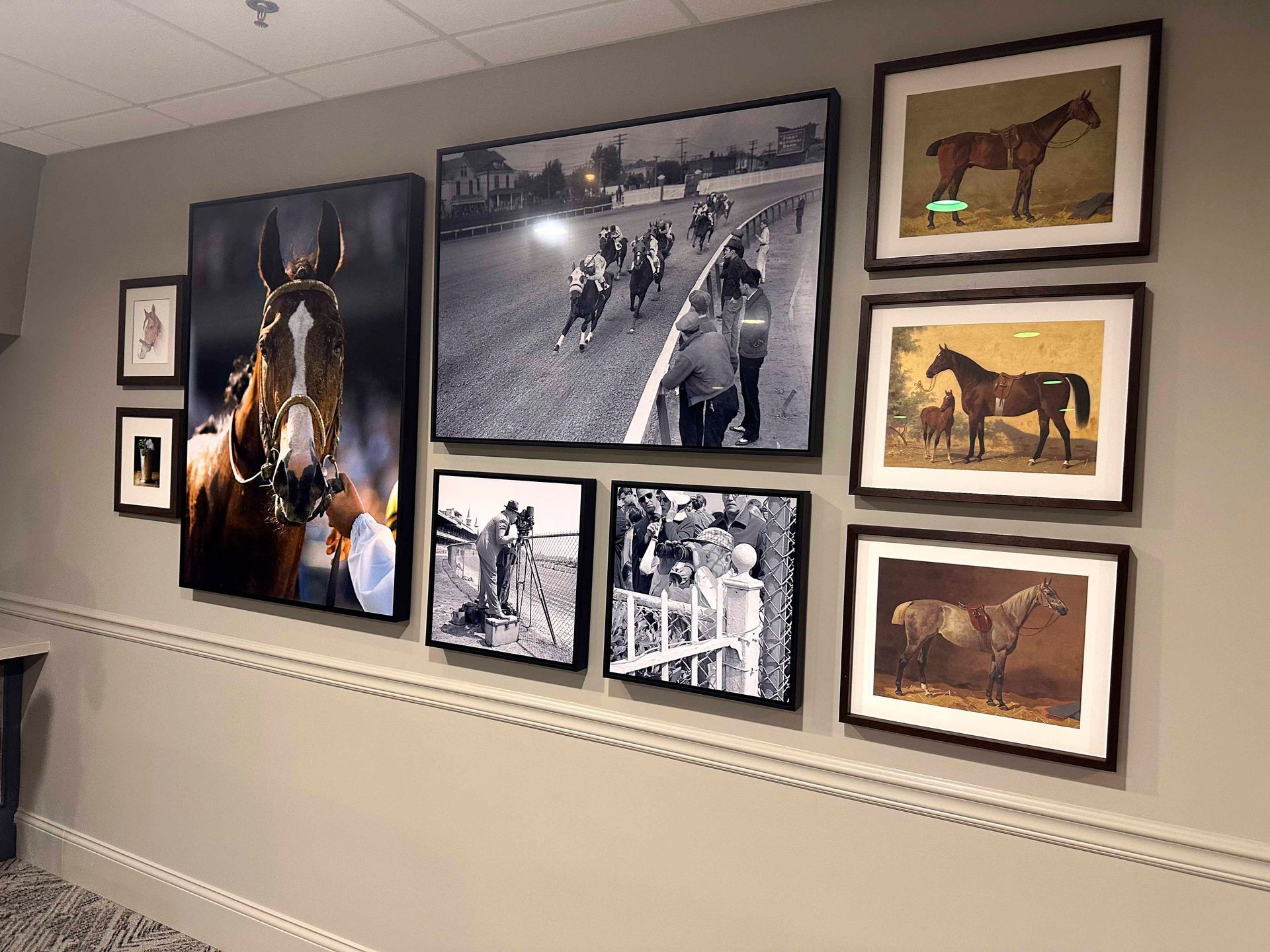 Wall display featuring framed horse racing prints and photos.
