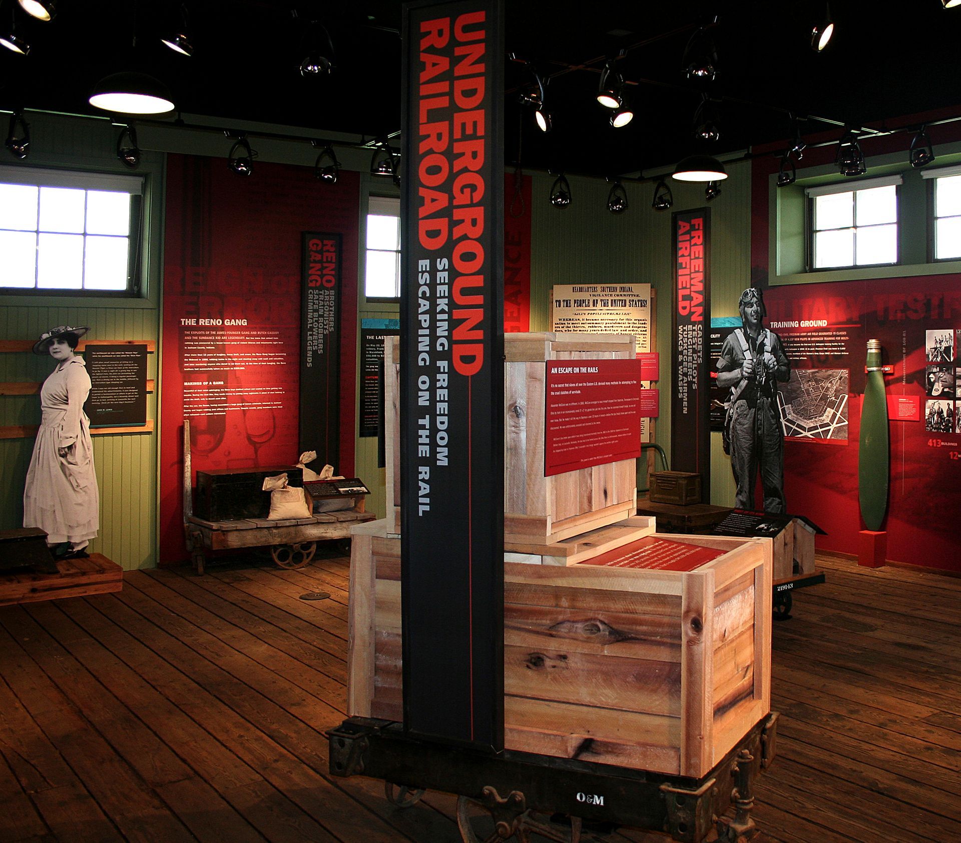 Museum exhibit: Underground Railroad display with wooden crates, text panels, and a statue.