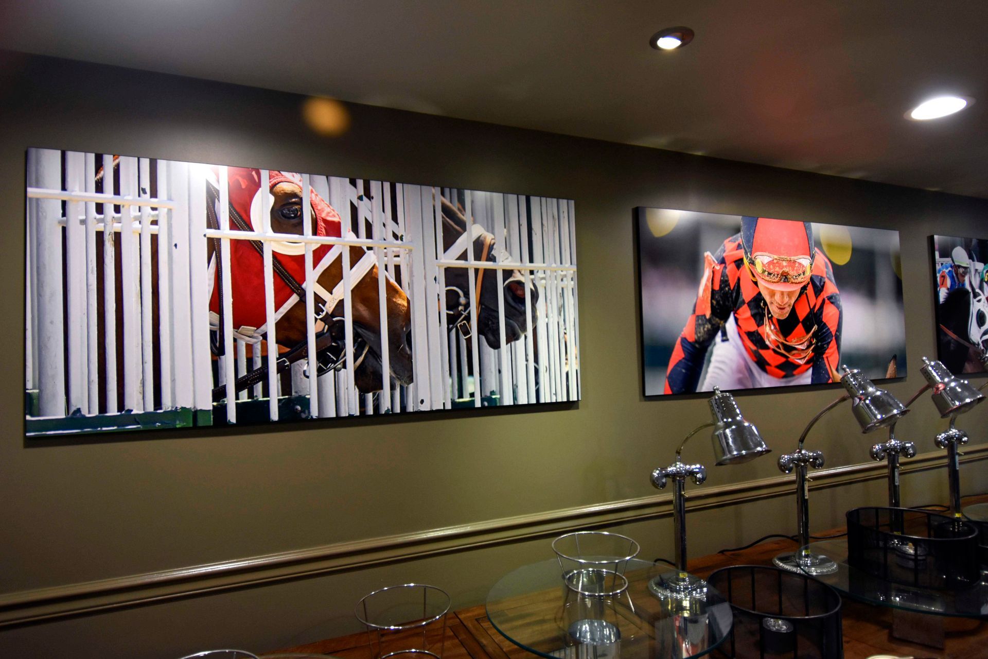 Racehorse art on wall, jockey in orange colors, near desk with lamps.
