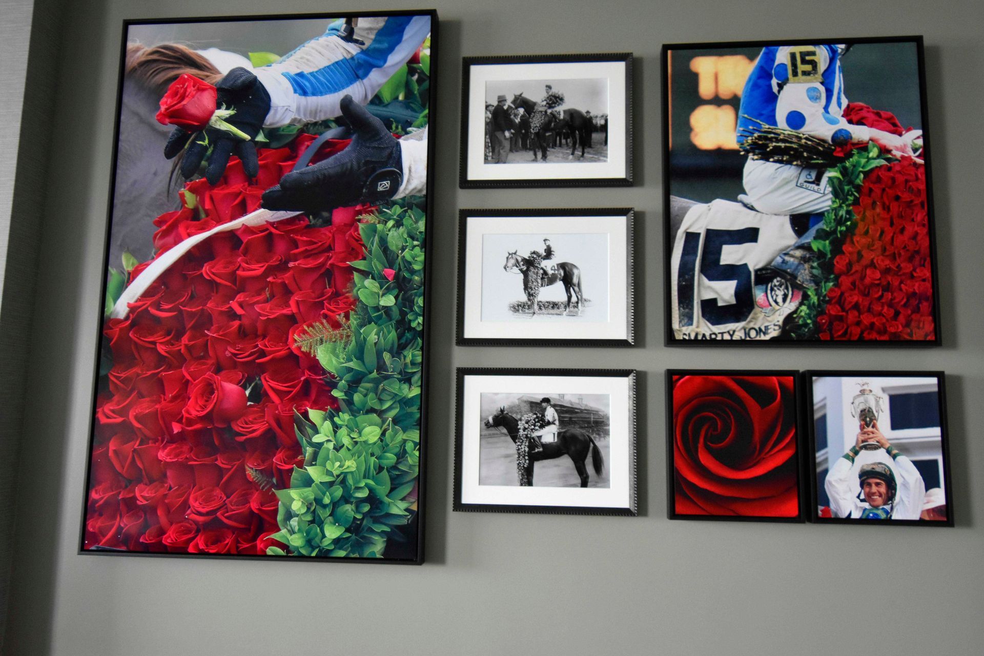 Wall display with horse racing art. Photos include roses, jockeys, and horses. Black frames.
