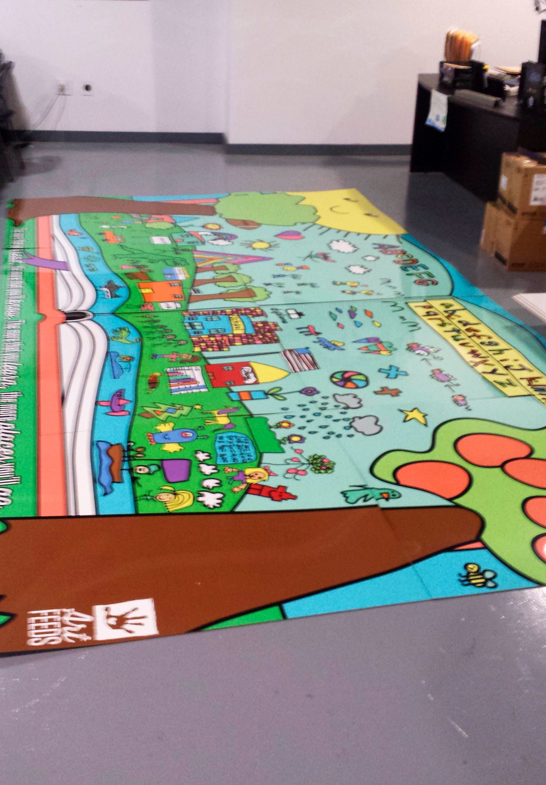 A colorful, large-format map laid out on a gray floor.