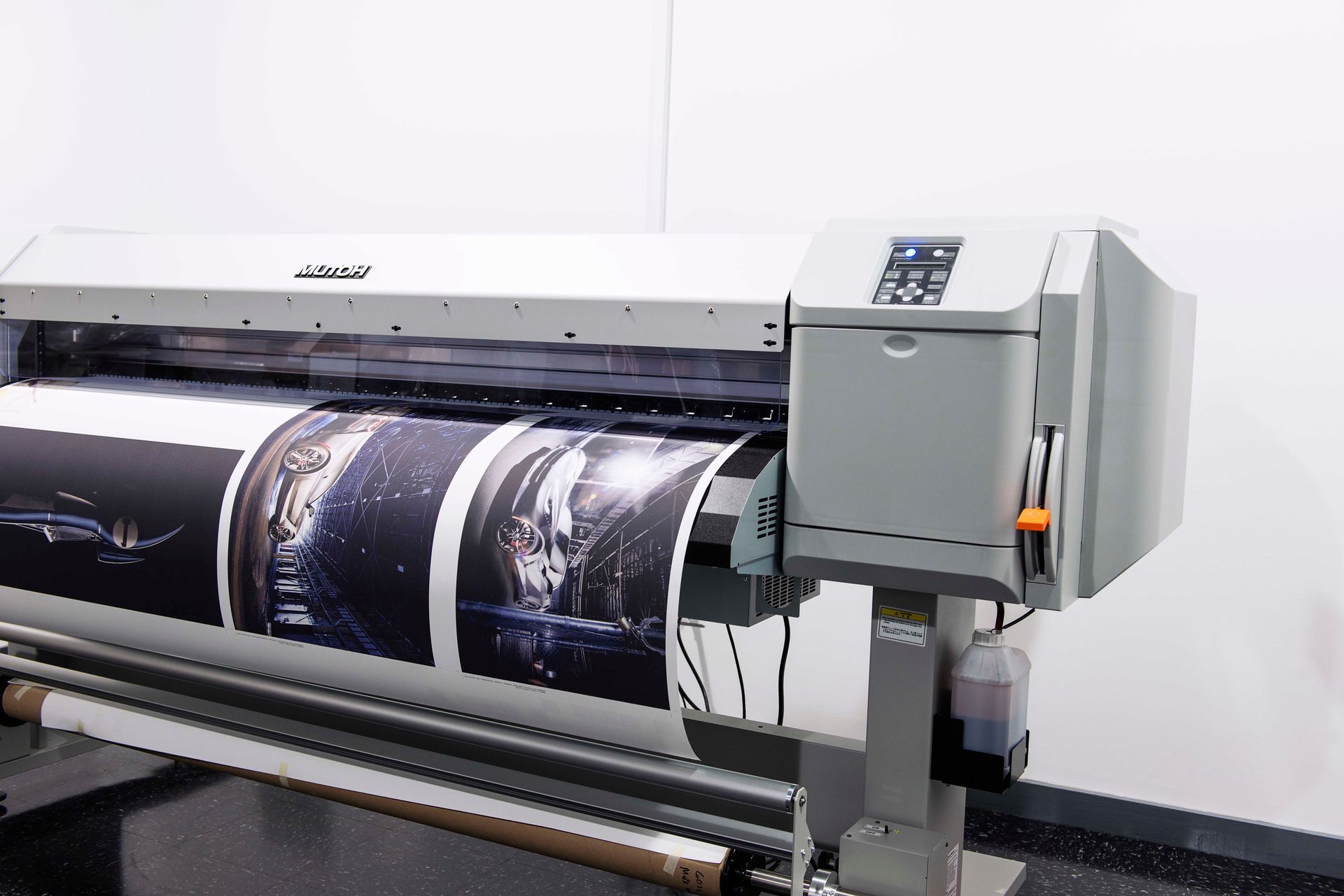 Large-format printer printing images of a dark space scene, with gray and black tones.