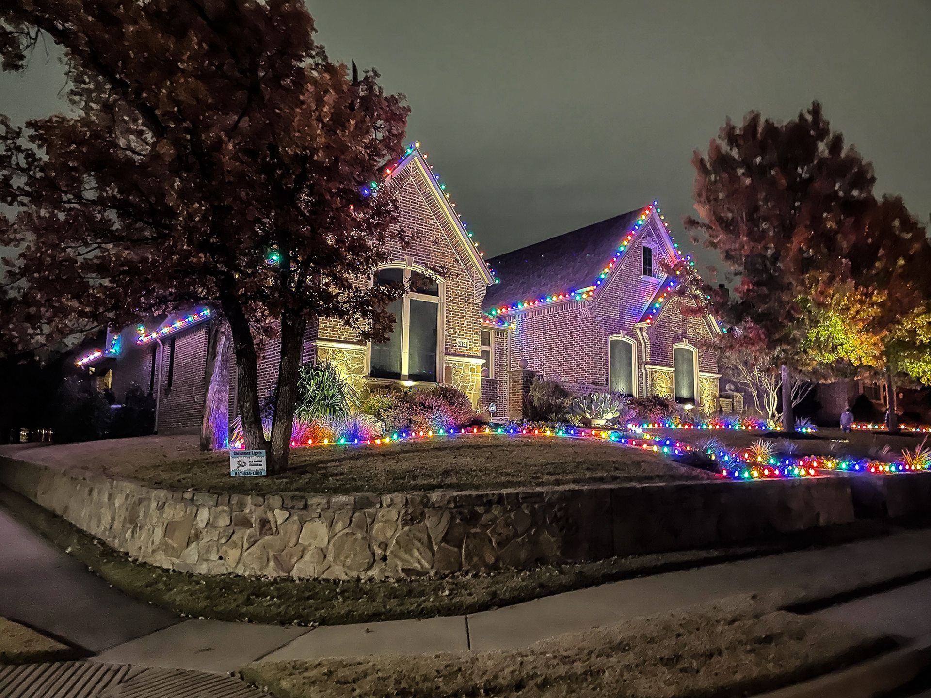 House covered in colorful Christmas lights at night.