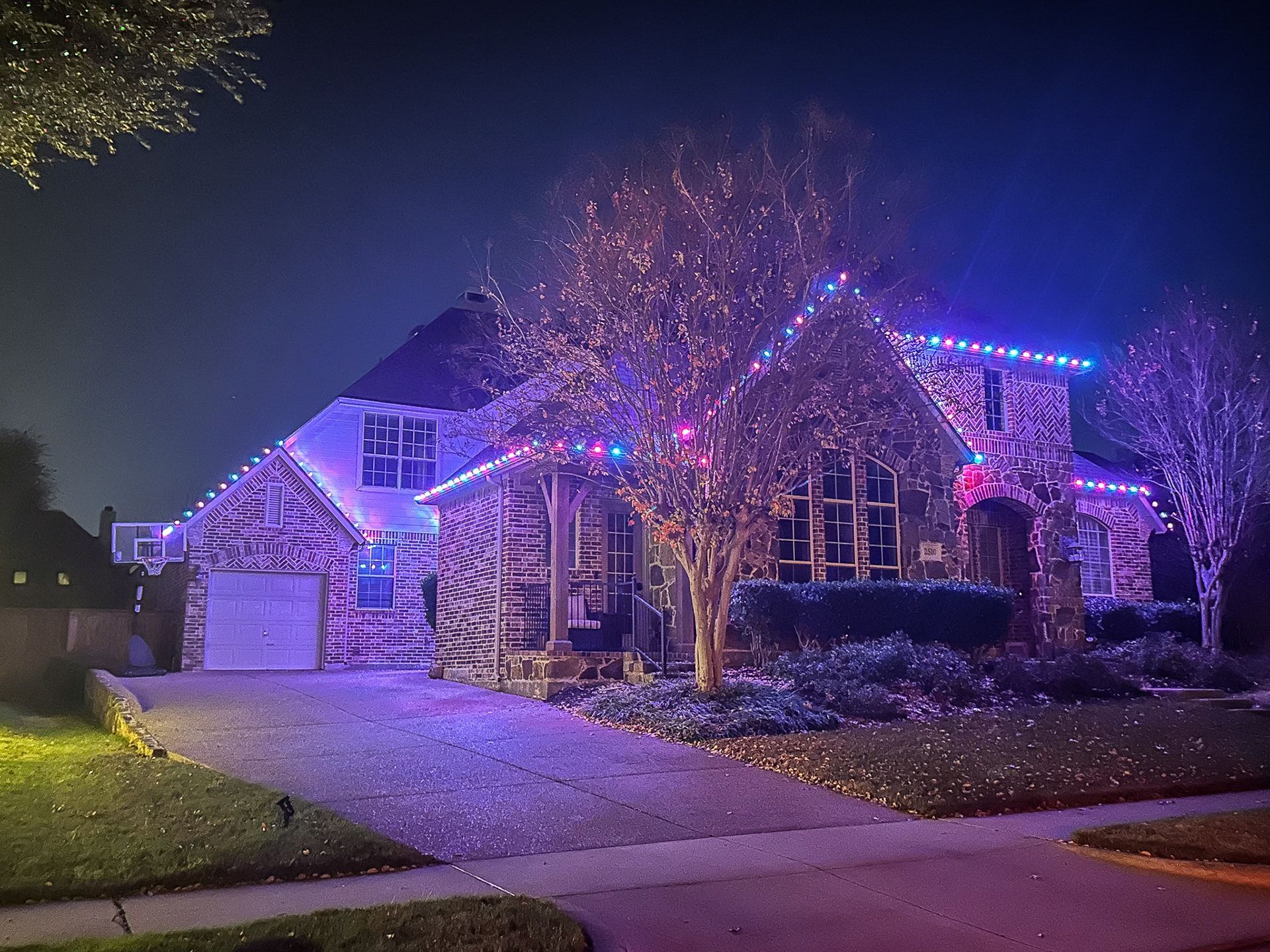 House at night decorated with colorful Christmas lights.