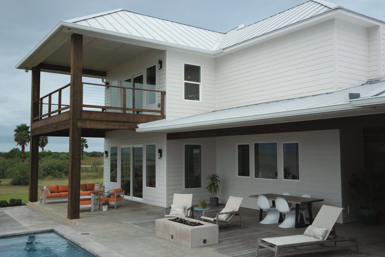 A white house with a swimming pool in front of it