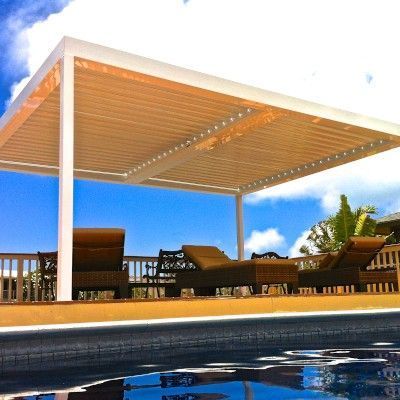 A pergola over a swimming pool with chairs underneath it