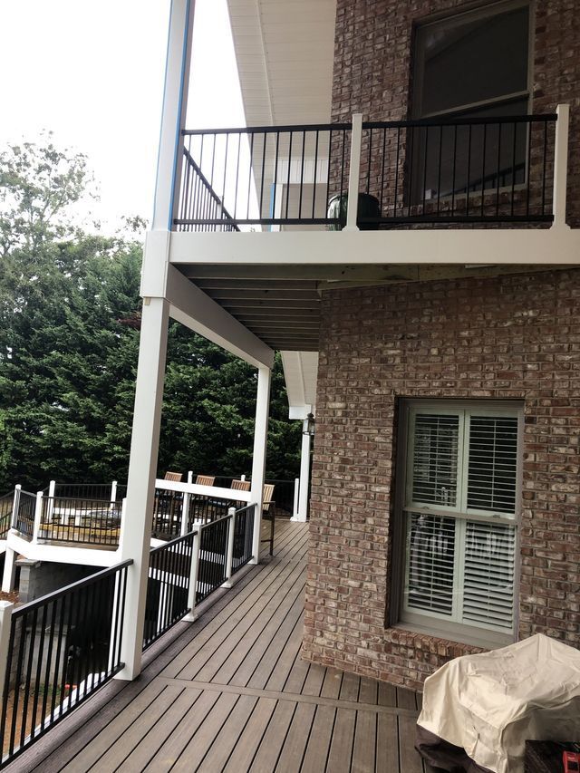 A brick house with a balcony and a grill on the deck