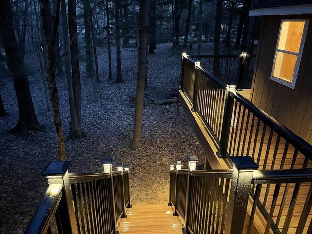 Stairs leading up to a house in the woods at night