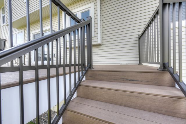 A set of stairs leading up to a house with a metal railing.
