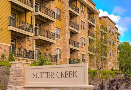 A large apartment building with a sign in front of it that says sutter creek.