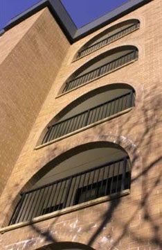 A brick building with arched windows and a metal railing