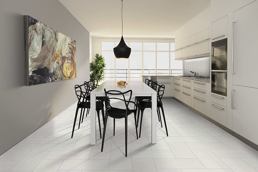 A kitchen with a table and chairs and a painting on the wall.