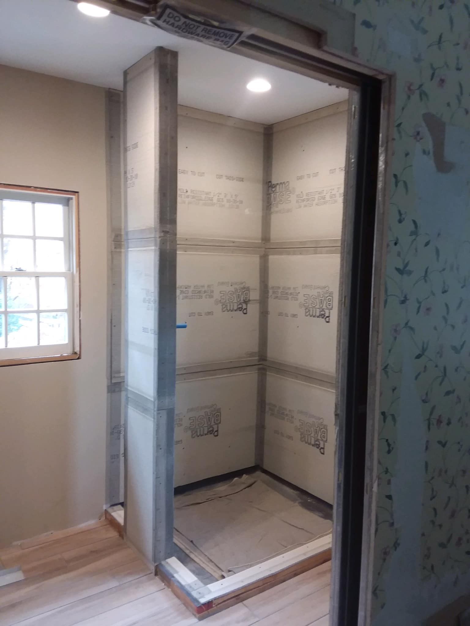 A bathroom under construction with a door open and a window.
