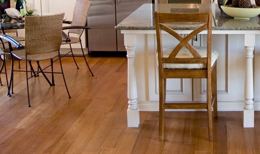 A kitchen with hardwood floors and a wooden chair